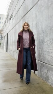 Bordeaux color longline wool coat,turtleneck, wide-leg jeans, boots and fold-over bag. 