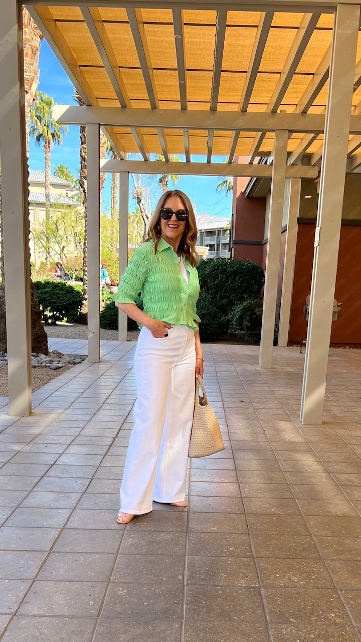 Spring outfit including white wide-leg jeans, white tank, green sweater, sandal, sunnies, tote.