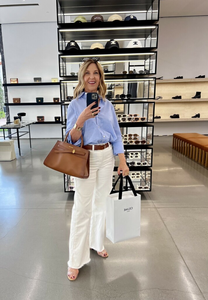 Shopping outfit. Ecru jeans, blue button-up, cognac accessories.