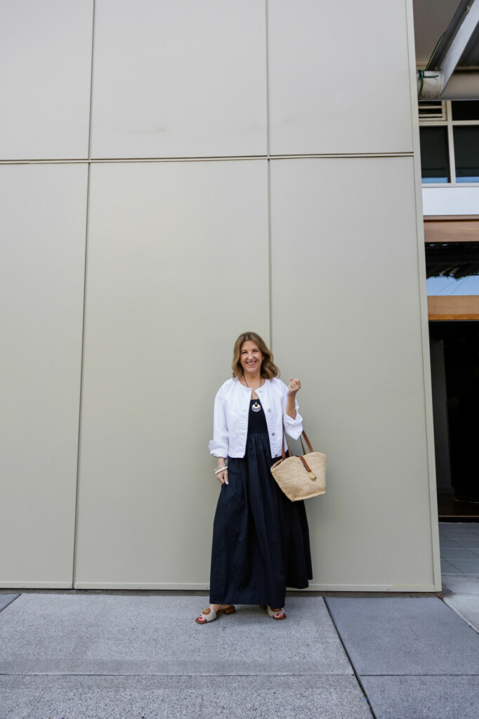 black maxi dress, white denim jacket and raffia tote